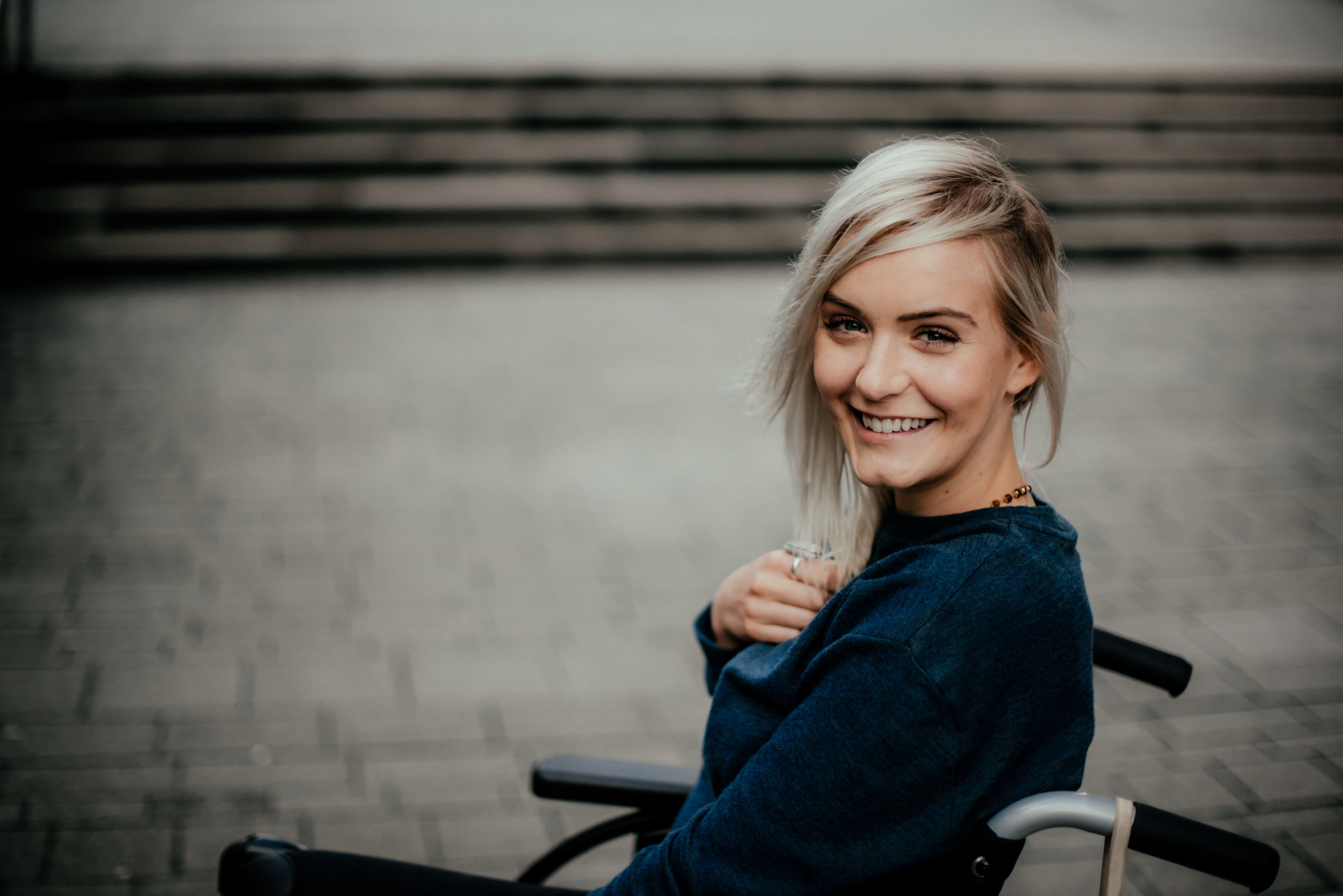 Portrait Of A Happy Blonde Girl In A Wheelchair
