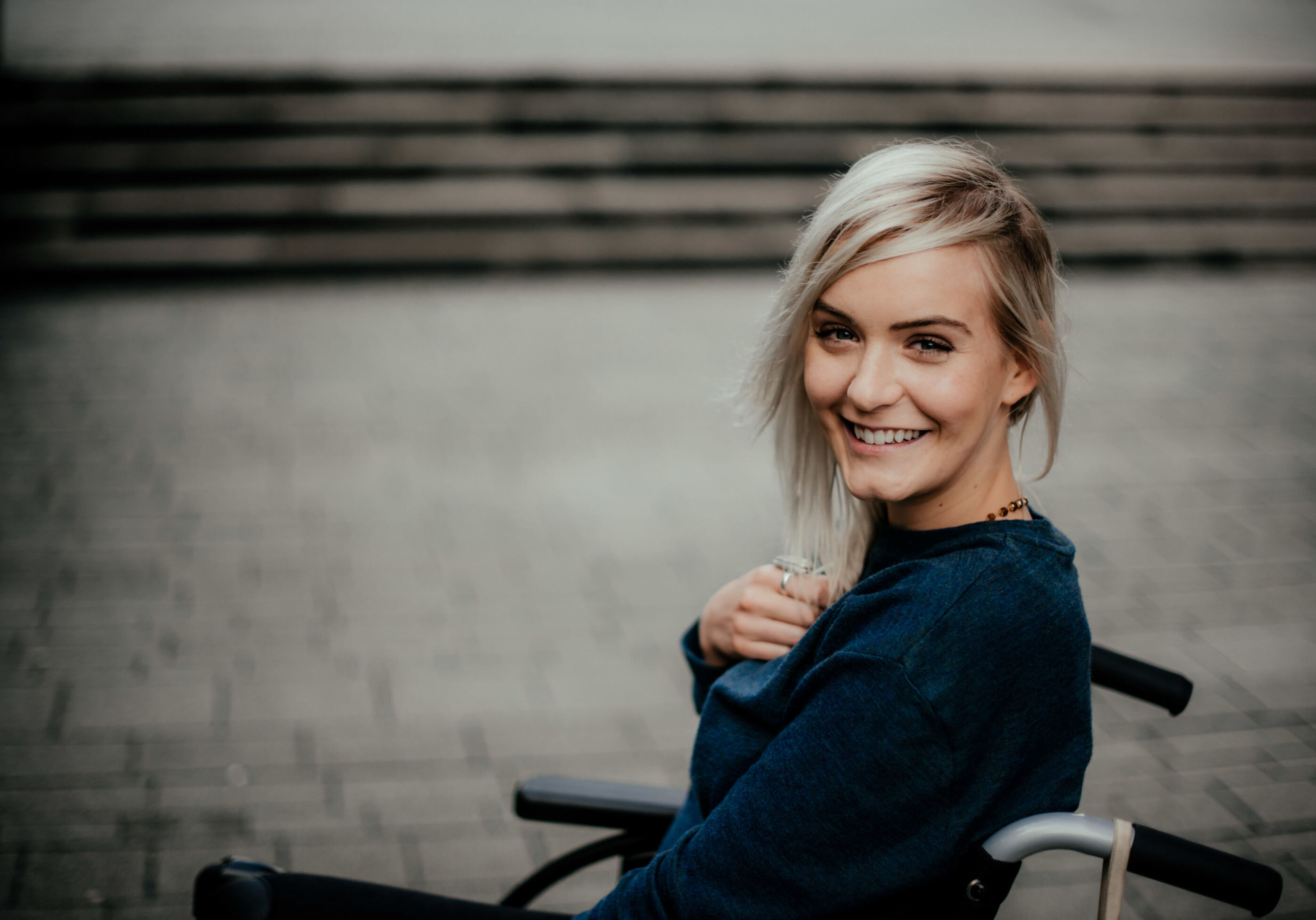 Portrait Of A Happy Blonde Girl In A Wheelchair